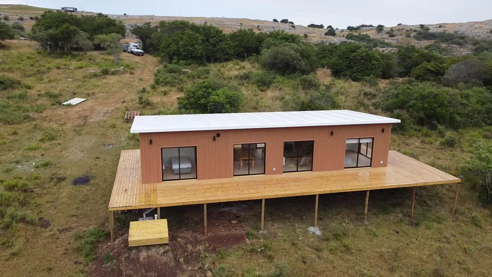 Casa de Intersteel23 en las sierras, con deck de madera y fachada en WPC
