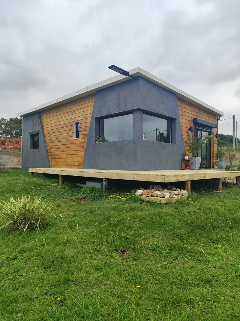Vivienda de Playa Grande con fachada gris, revestimiento de aspecto madera y deck